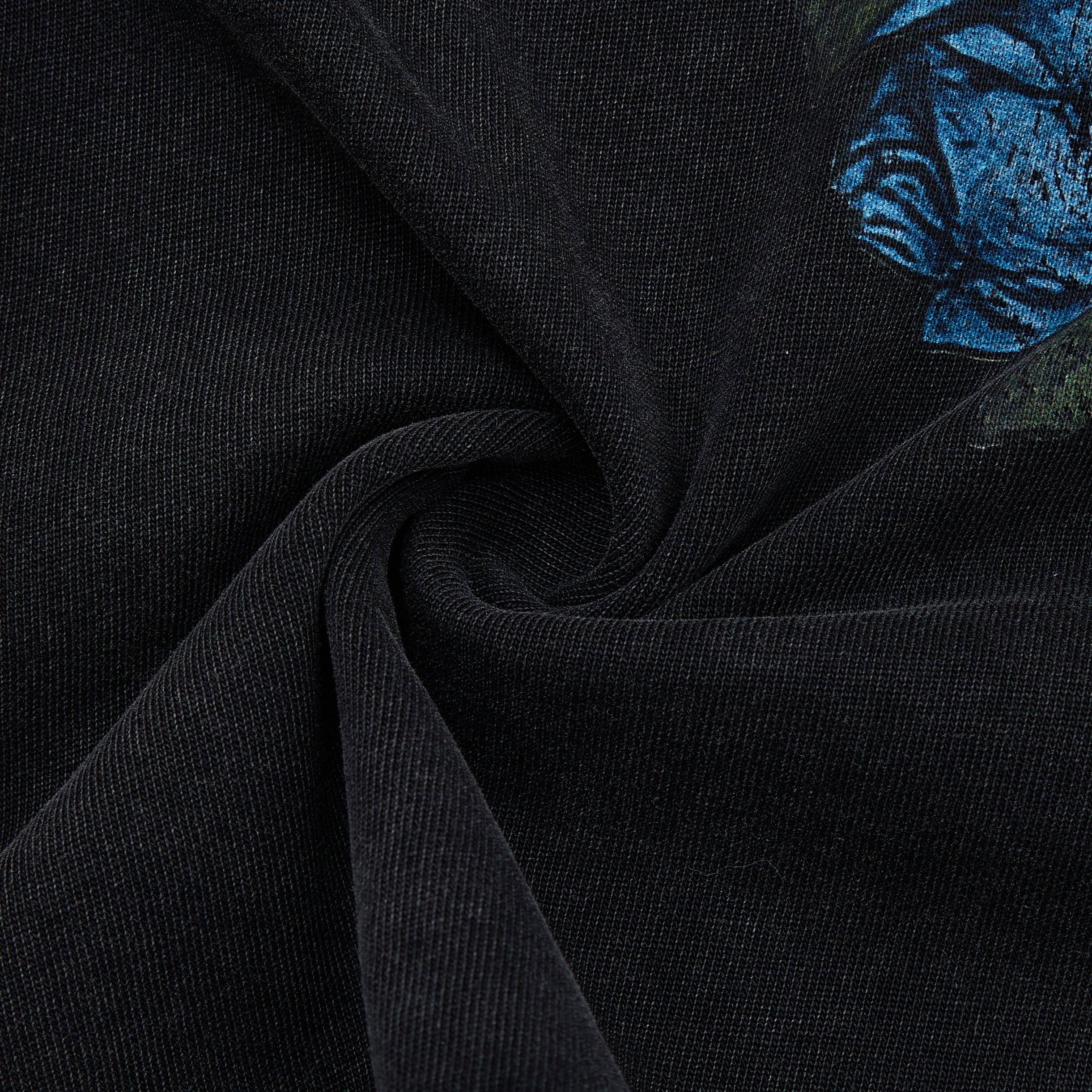Close-up of black fabric with blue floral embroidery