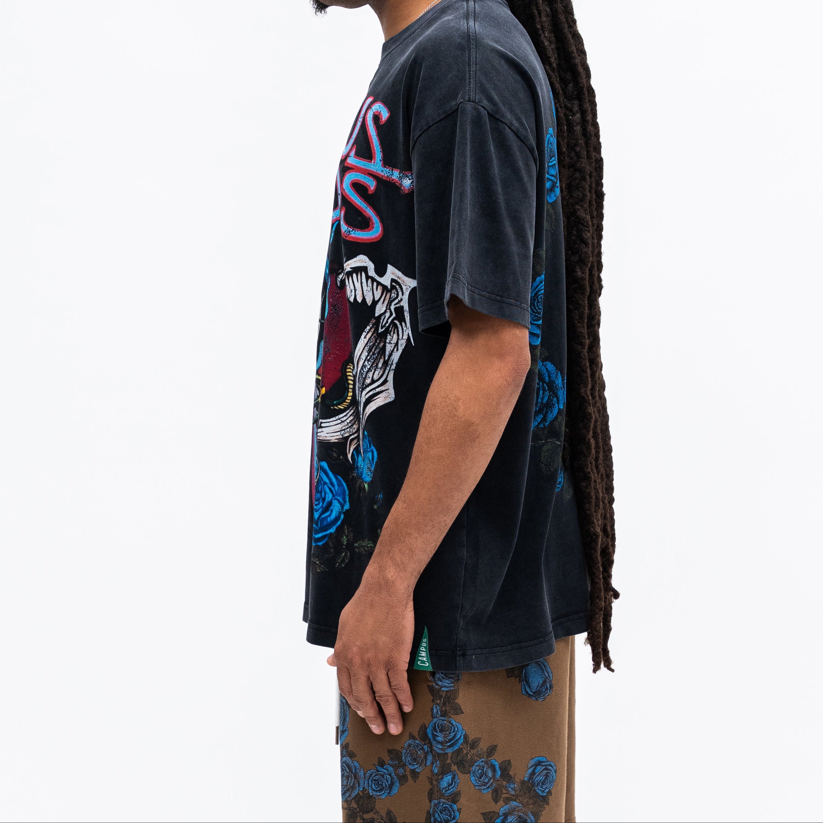 Person wearing a dark graphic t-shirt with a white background