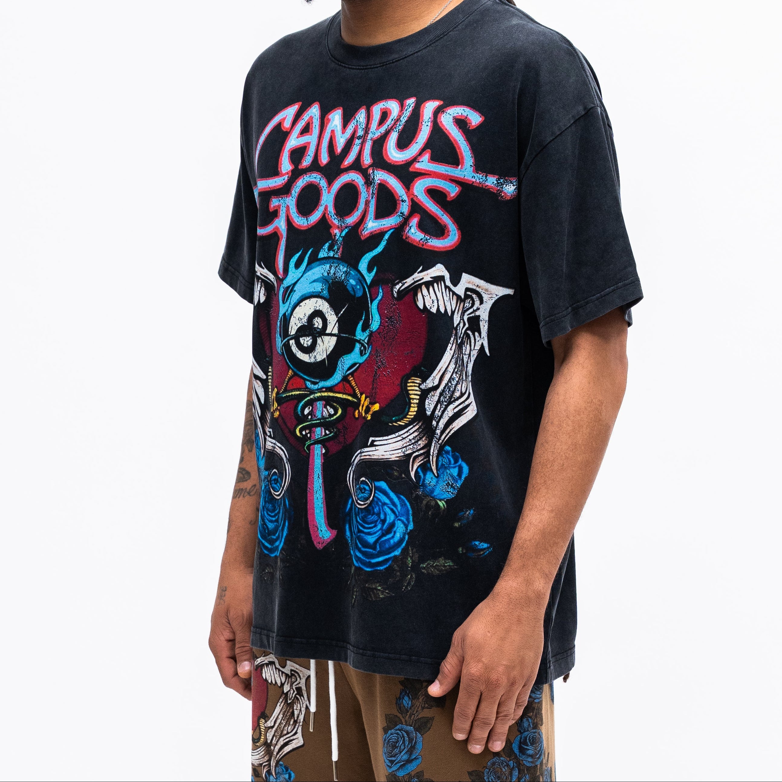 Person wearing a black t-shirt with colorful graphics and text on a white background