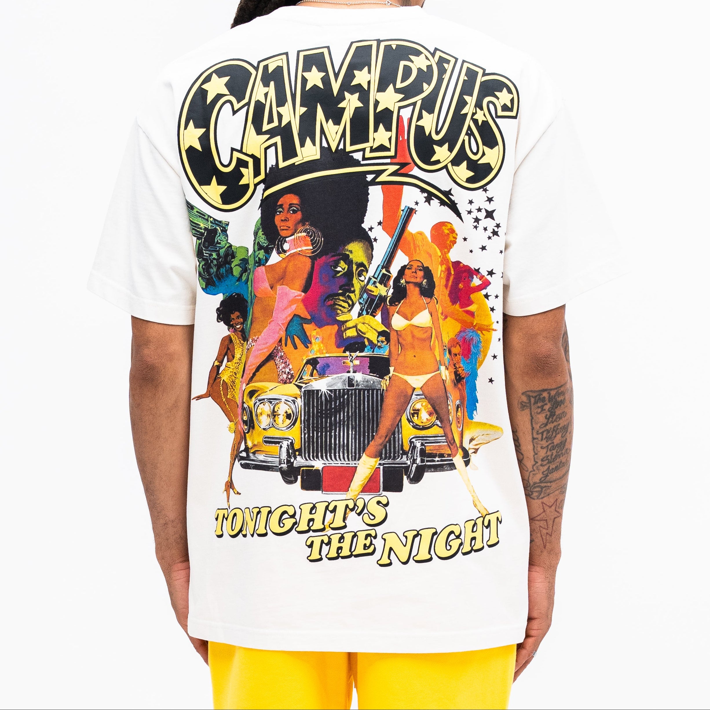 Person wearing a white t-shirt with a colorful graphic design on the back, featuring text and images.