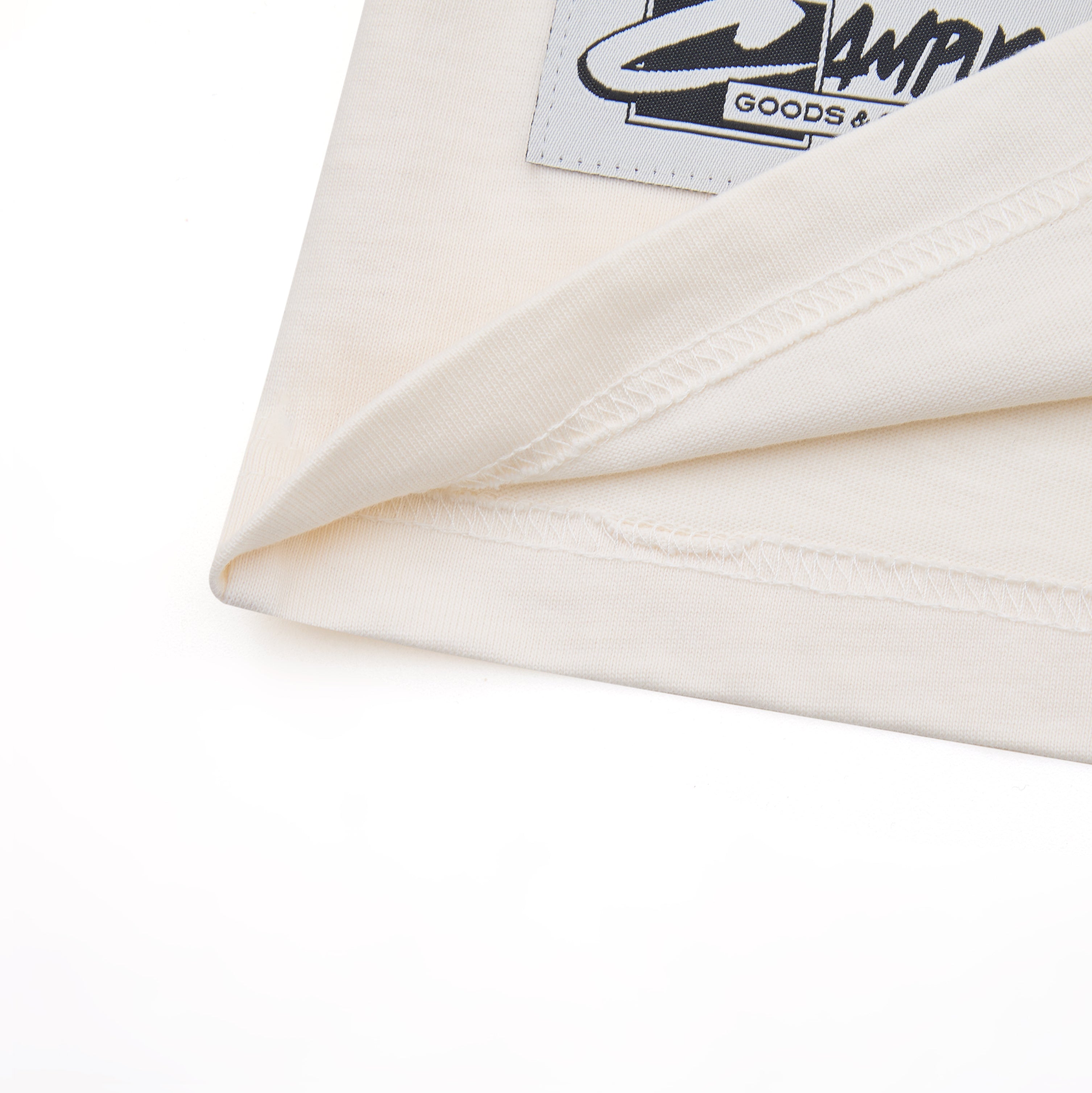 Close-up of a white shirt with a brand label on a white background