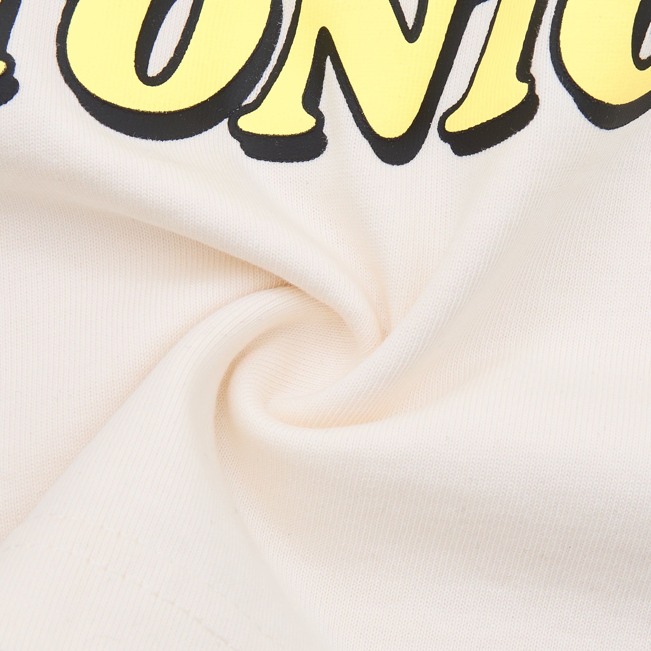 Close-up of a white fabric with yellow text on a white background