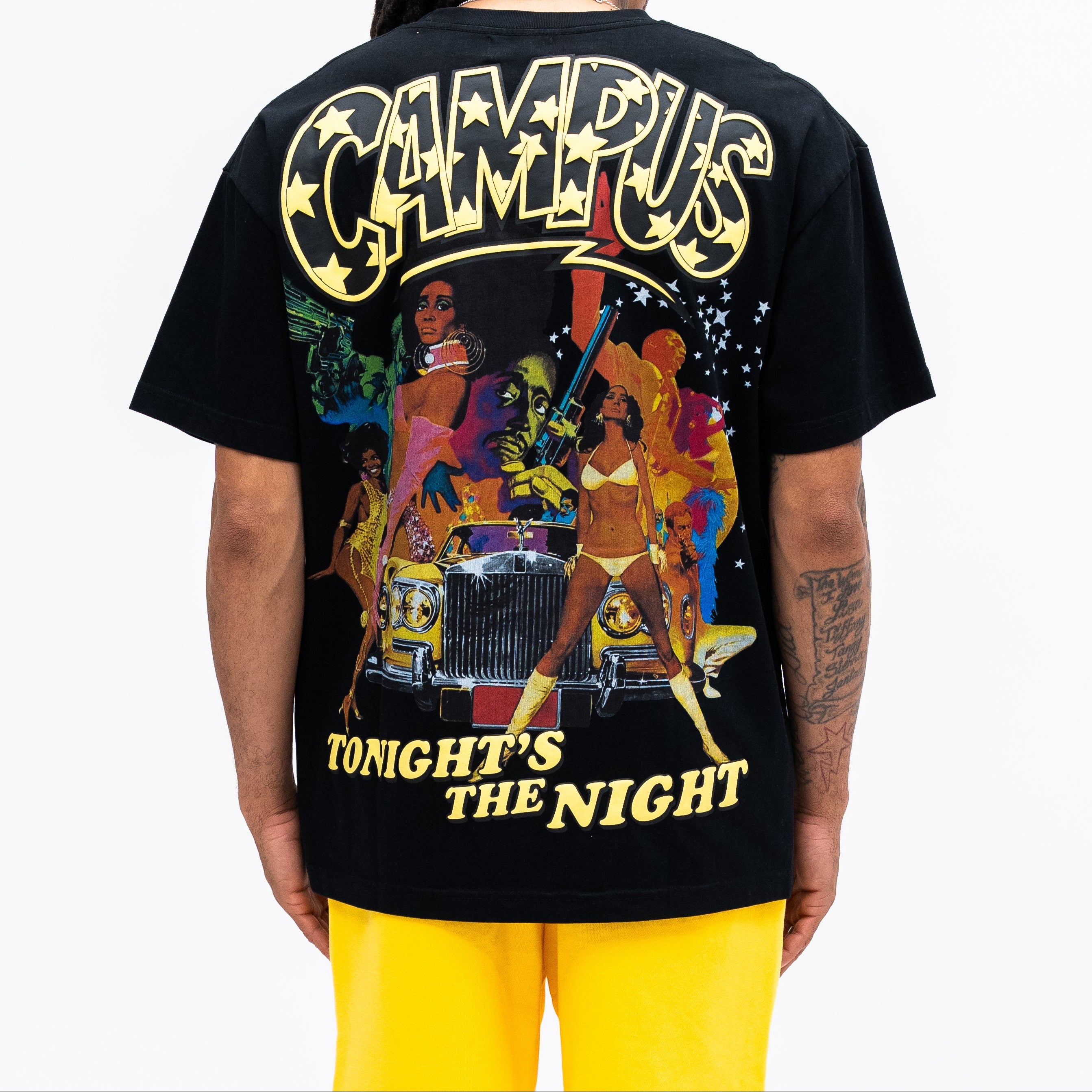 Person wearing a black t-shirt with colorful graphic design and text on the back