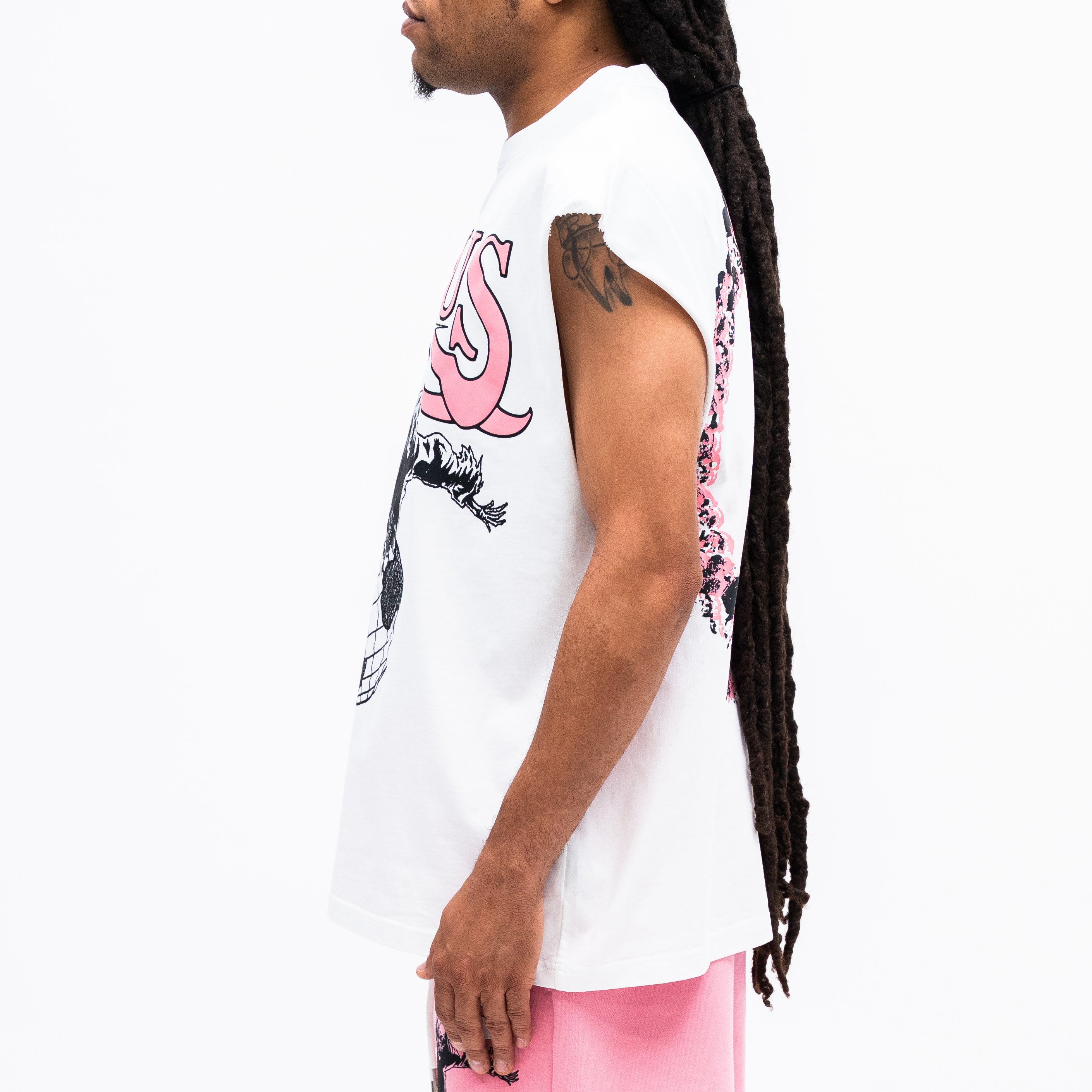 Person wearing a white t-shirt with pink and black graphics on a plain background