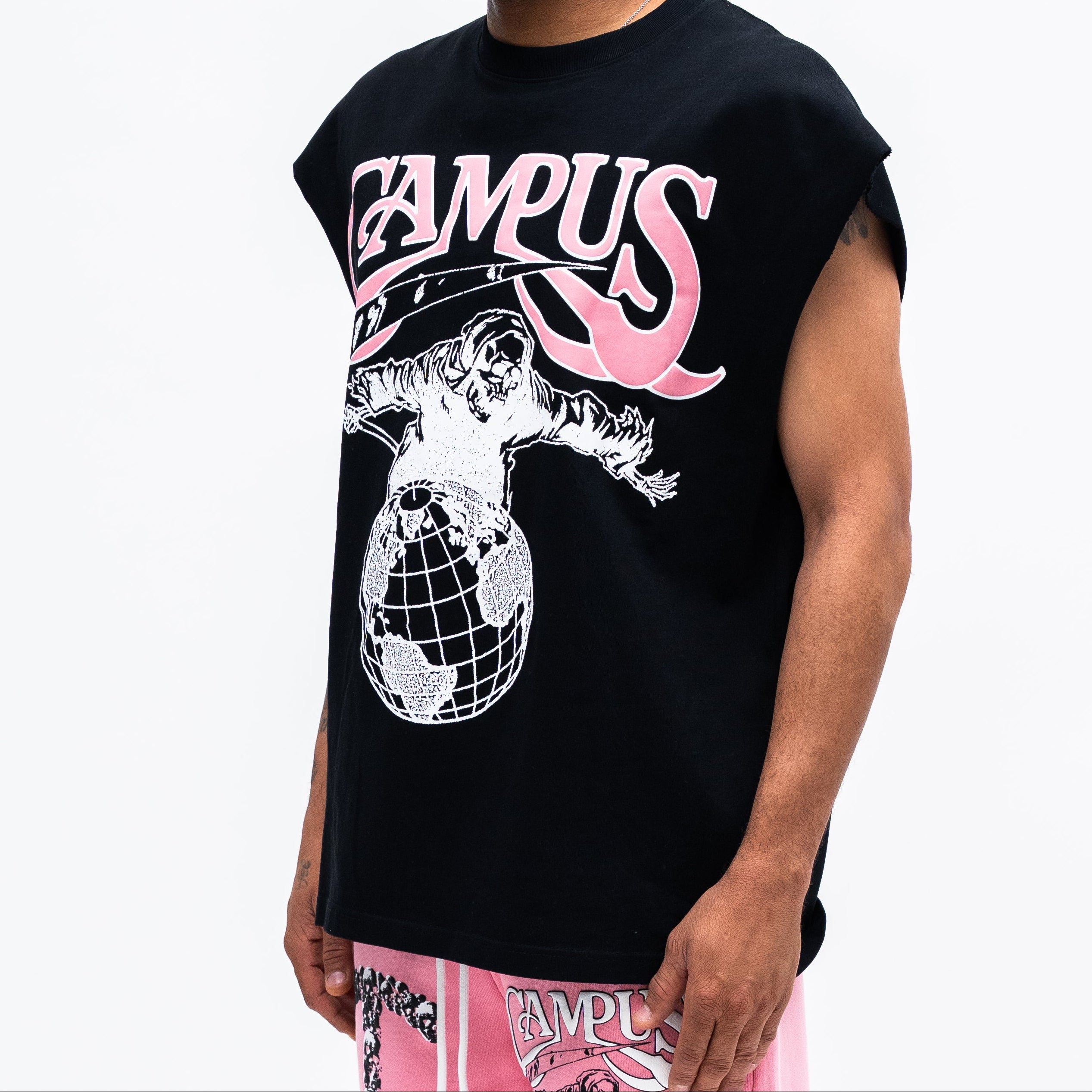 Person wearing a black sleeveless shirt with pink and white graphics on a white background