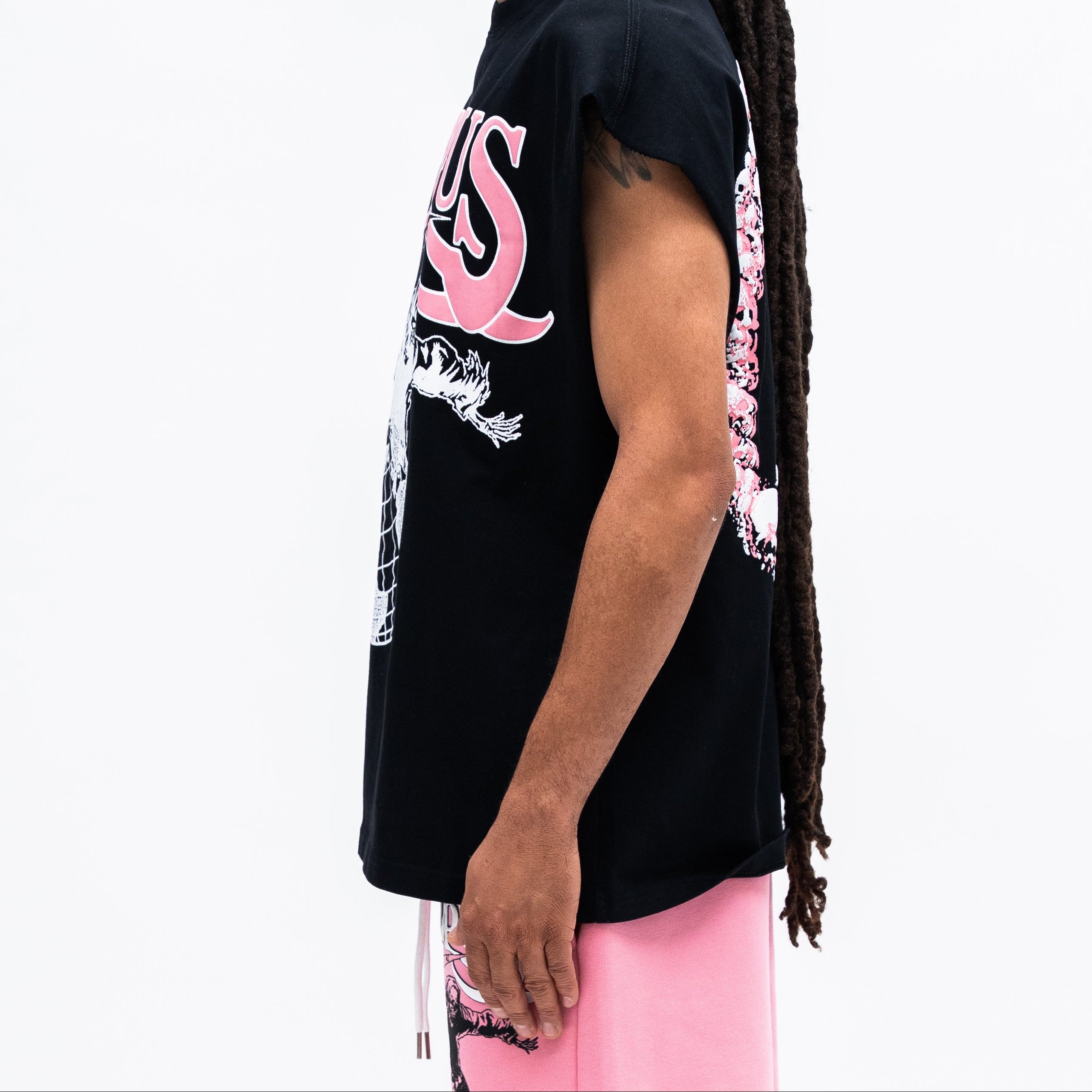 Person wearing a black t-shirt with pink and white graphics on a white background