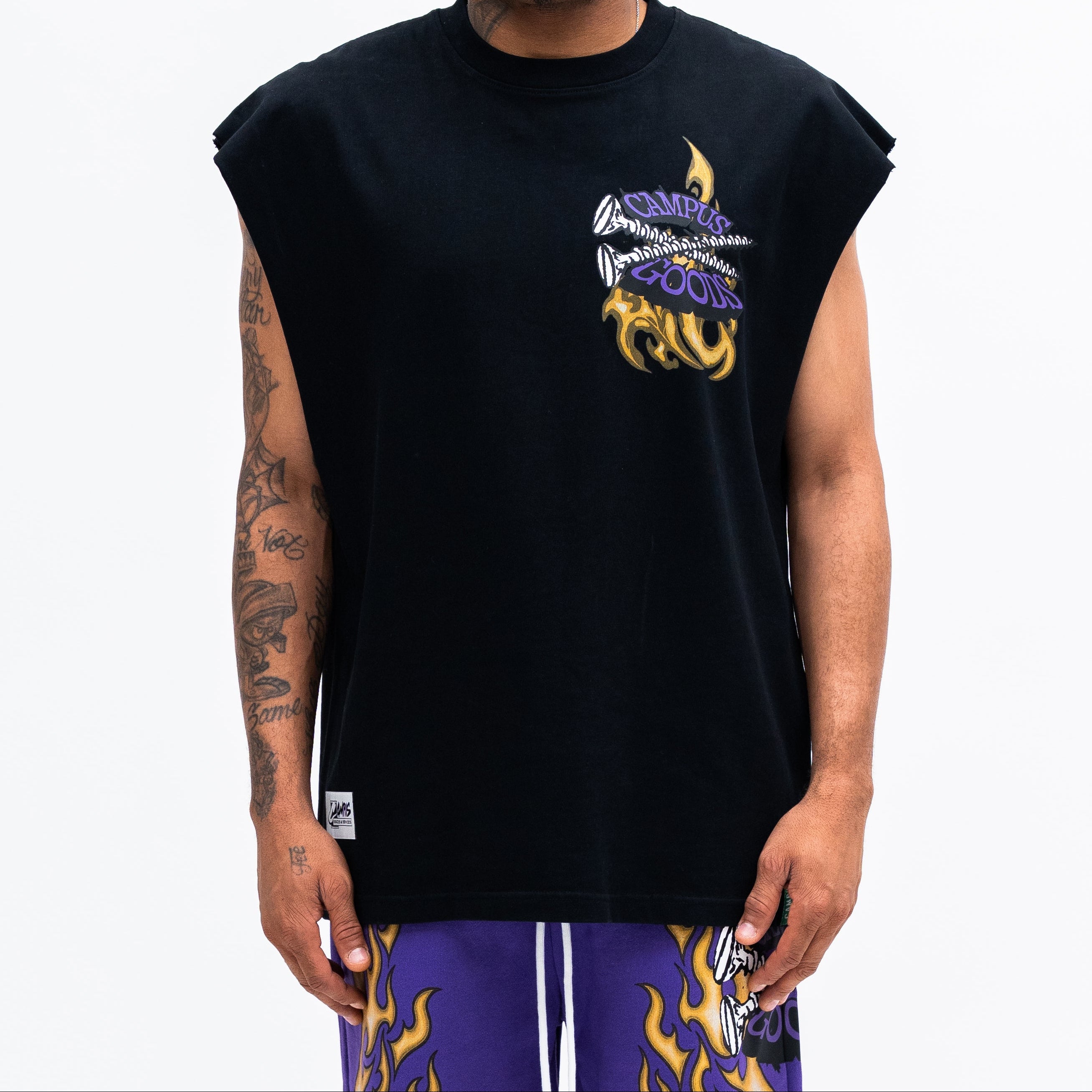 Person wearing a black sleeveless shirt with a logo and purple shorts with a similar design on a white background