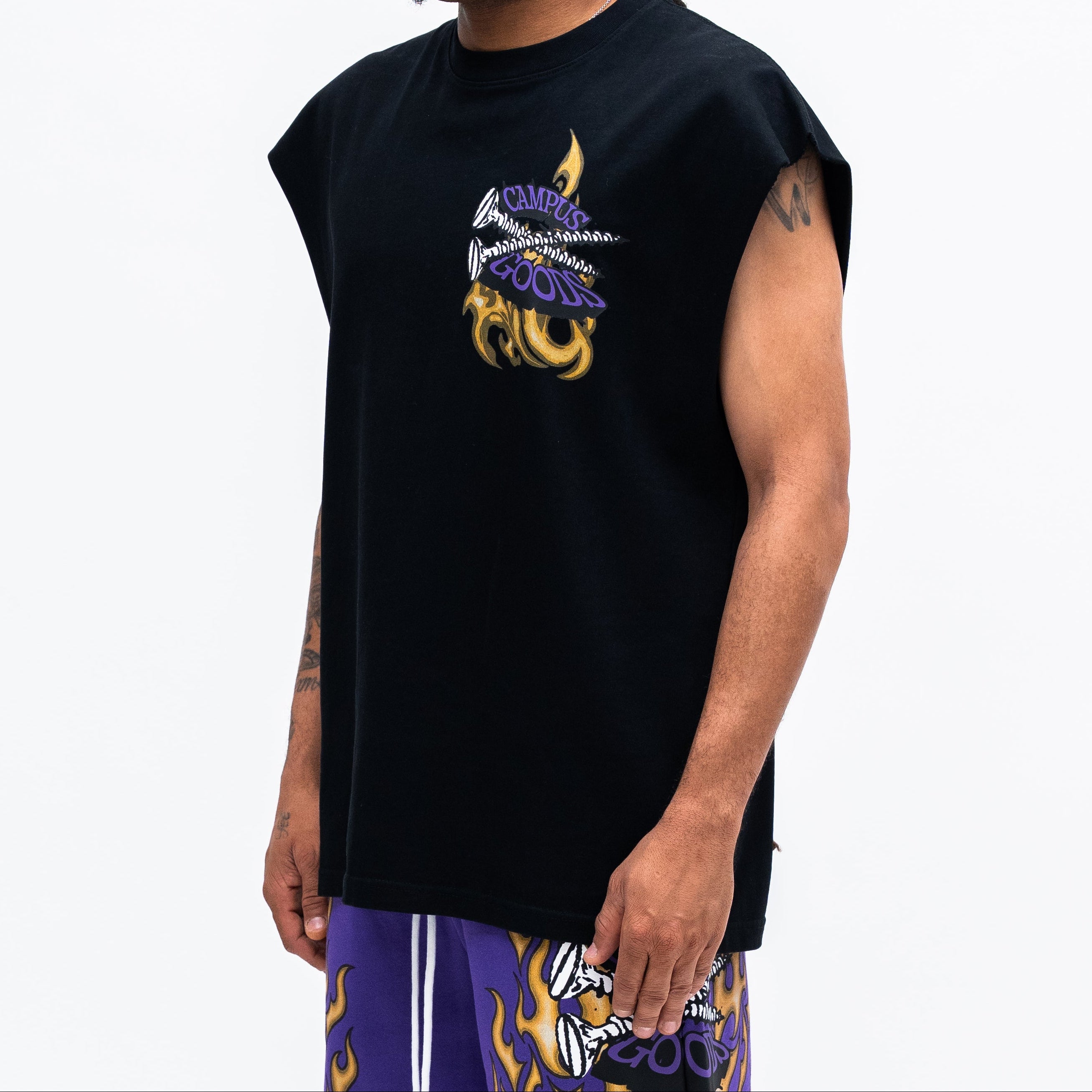 Man wearing a black sleeveless shirt with a colorful design on a white background
