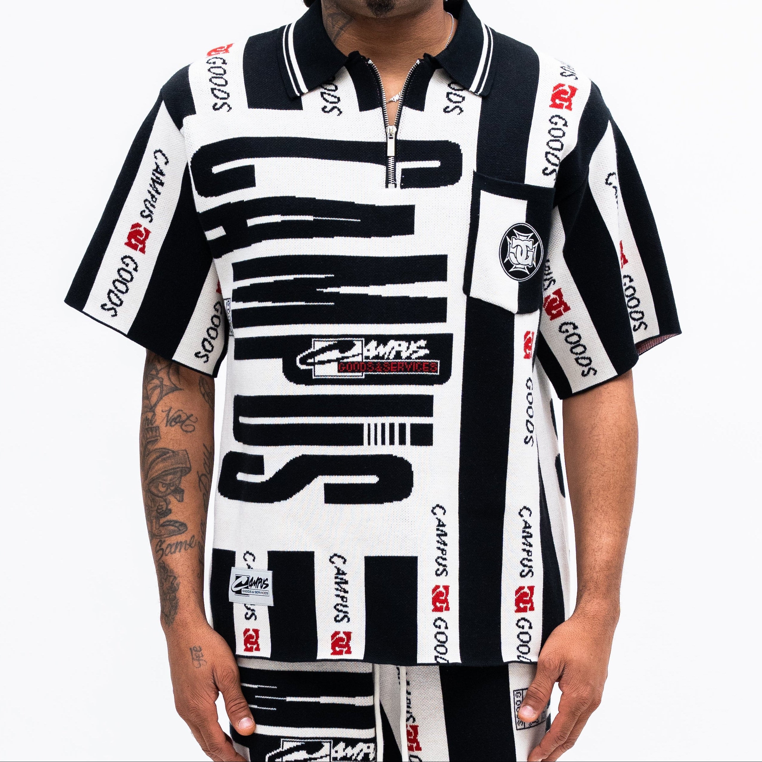 Man wearing a black and white patterned shirt with visible branding on a white background