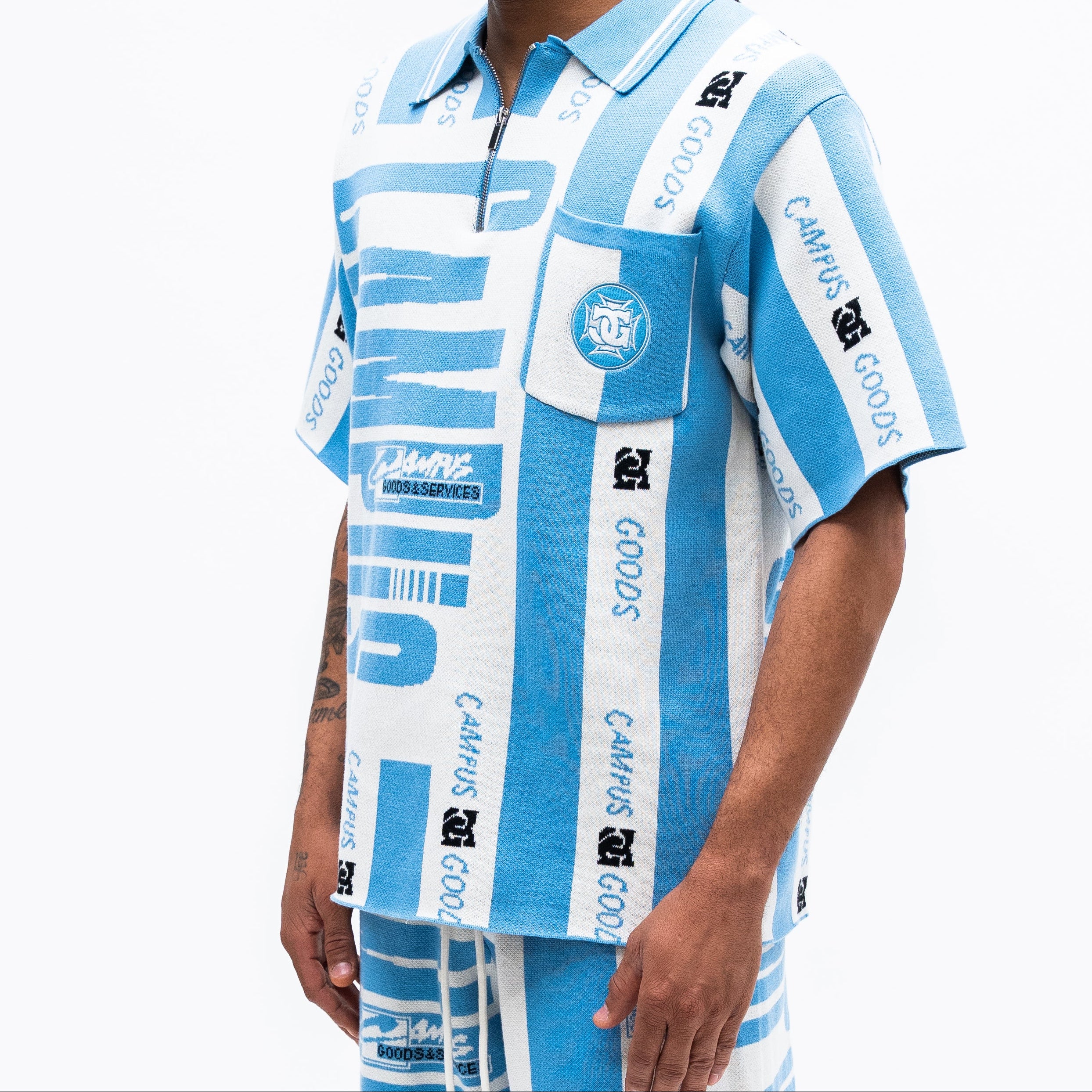 Person wearing a blue and white patterned CAMPUS GOODS zip shirt on a white background