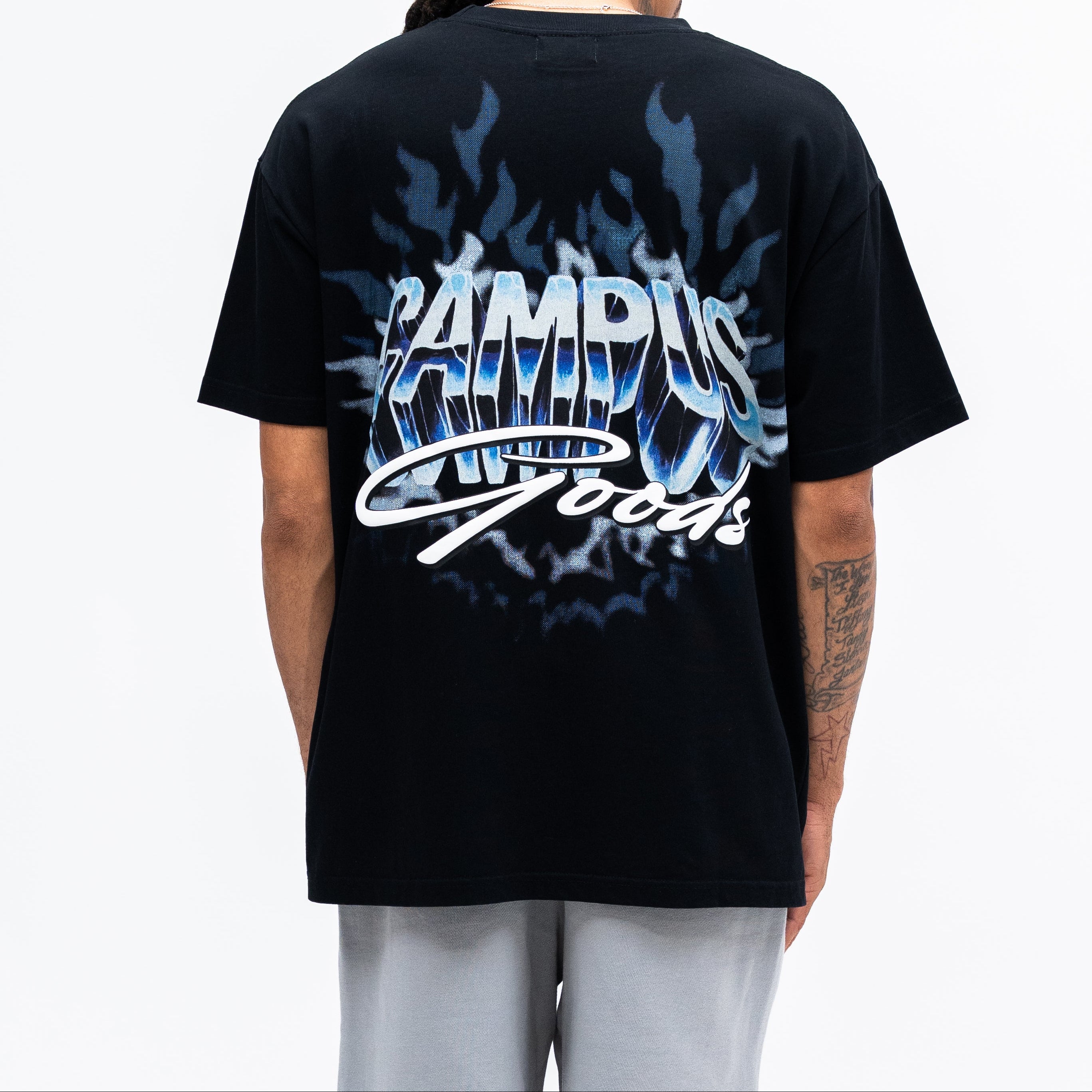 Person wearing a black t-shirt with 'Campus Goods' design on the back against a white background