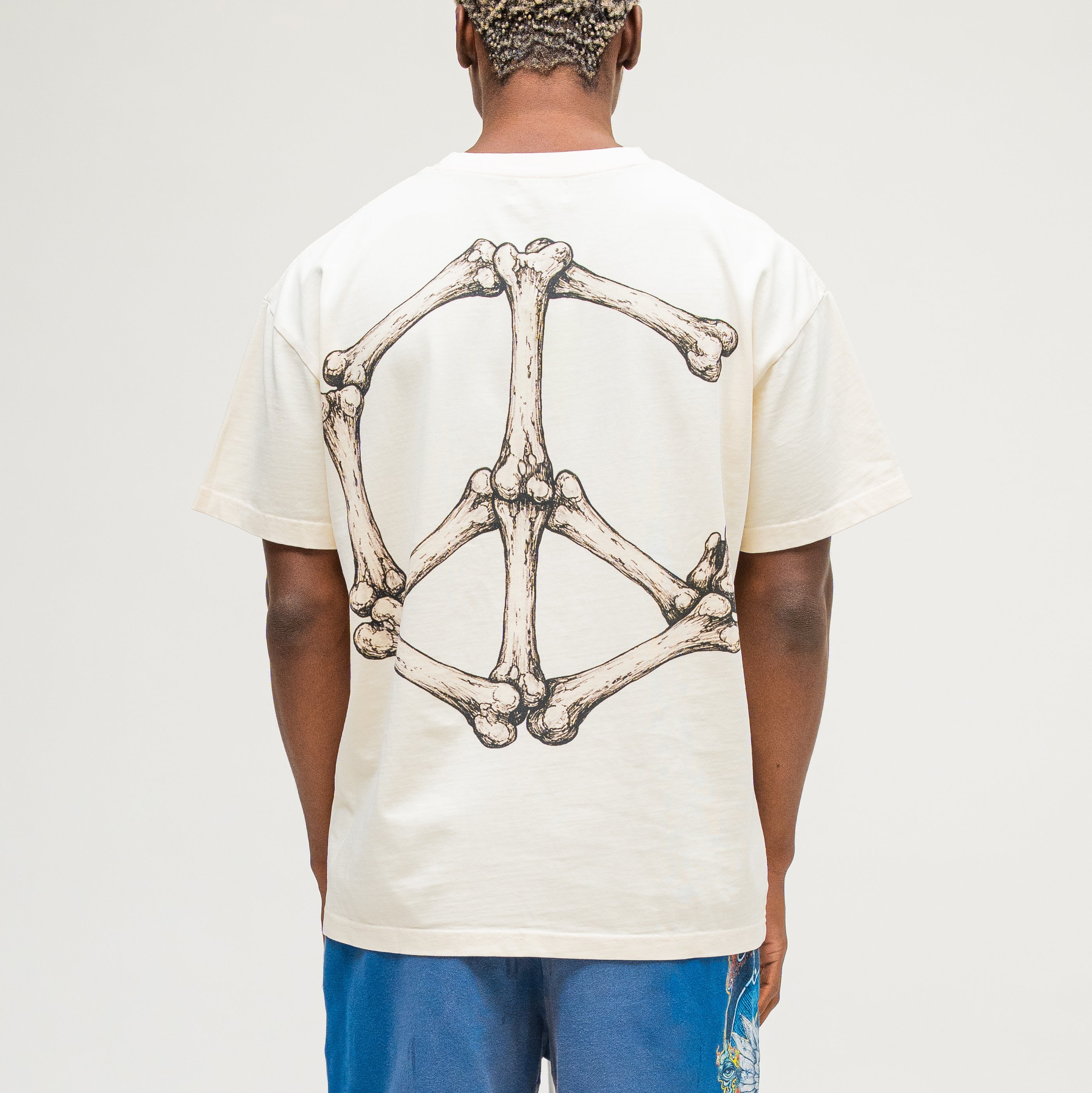 Campus Goods cream tee, back view featuring a large peace sign made of illustrated bones