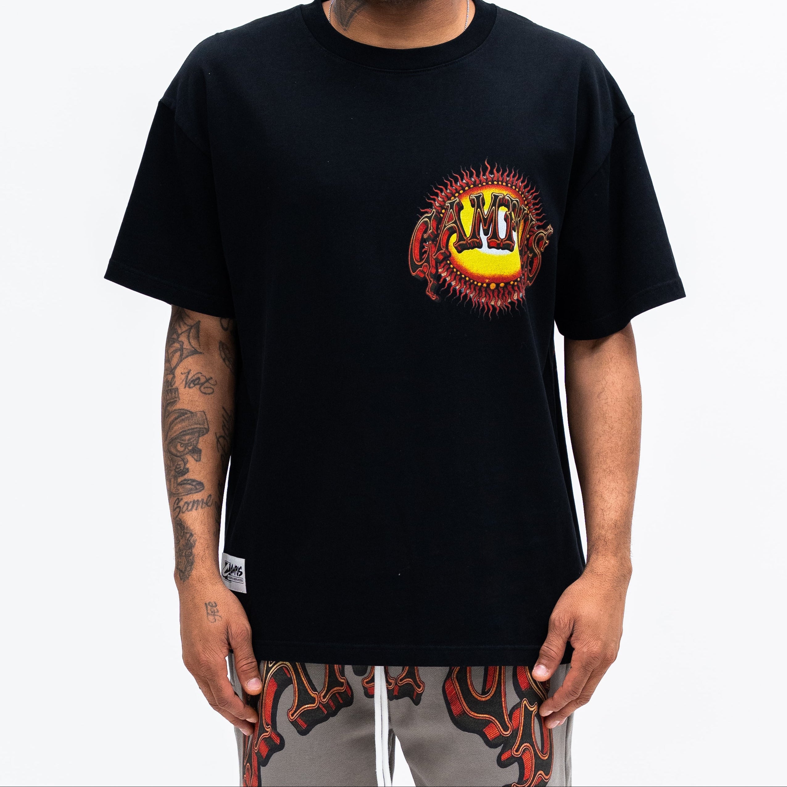 Man wearing a black t-shirt with a colorful graphic design on a white background