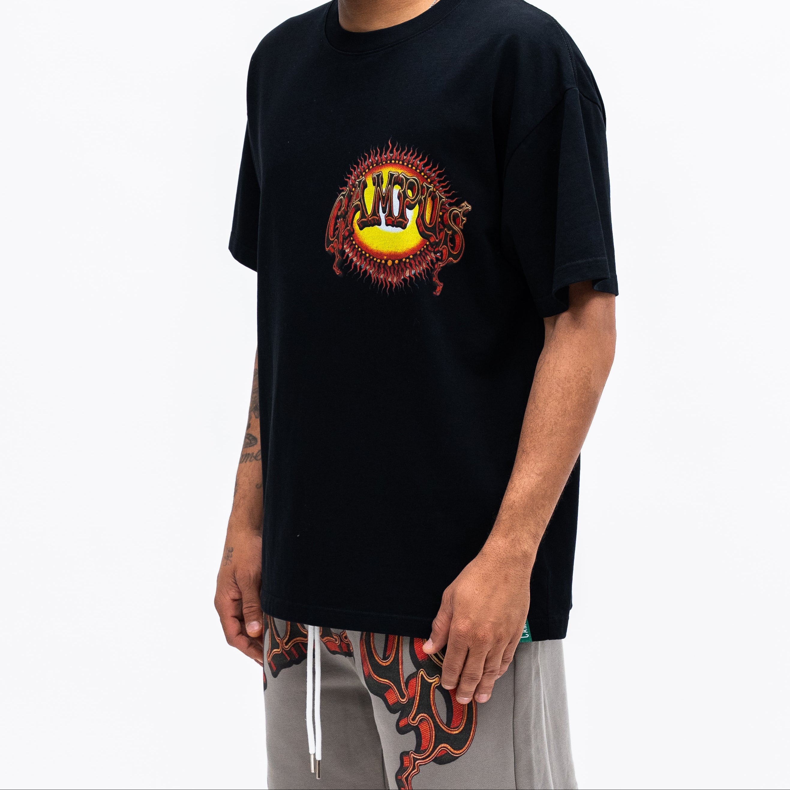 Man wearing a black t-shirt with a colorful logo on a white background