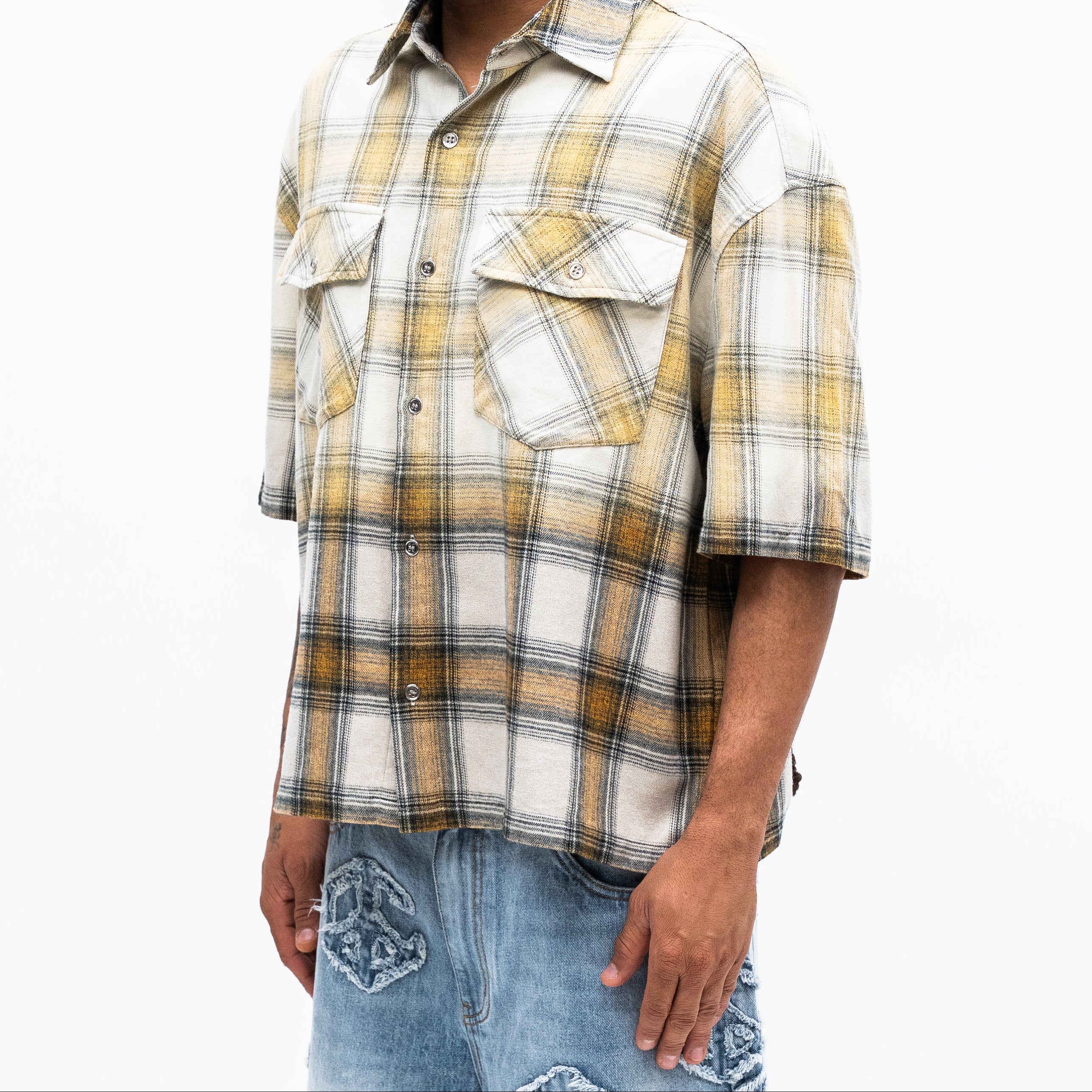 Man wearing a plaid shirt and jeans on a white background