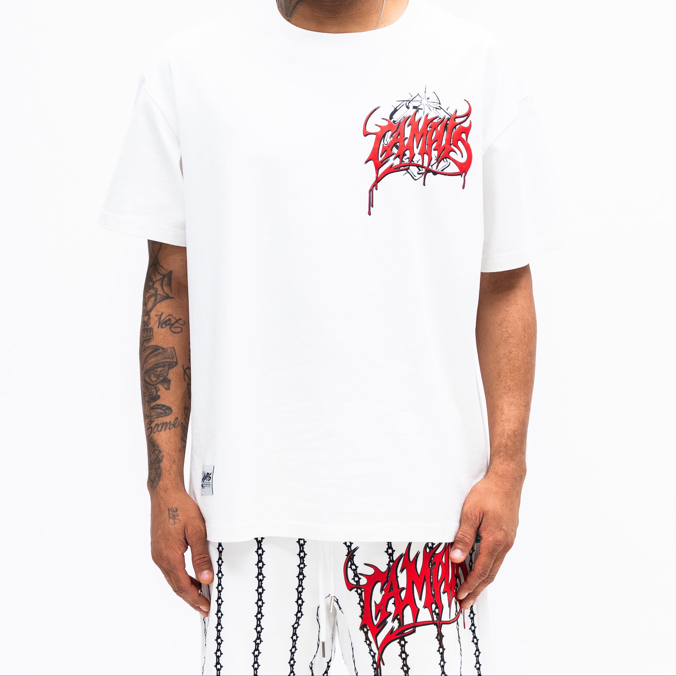 Person wearing a white t-shirt with red and black graphics on a white background