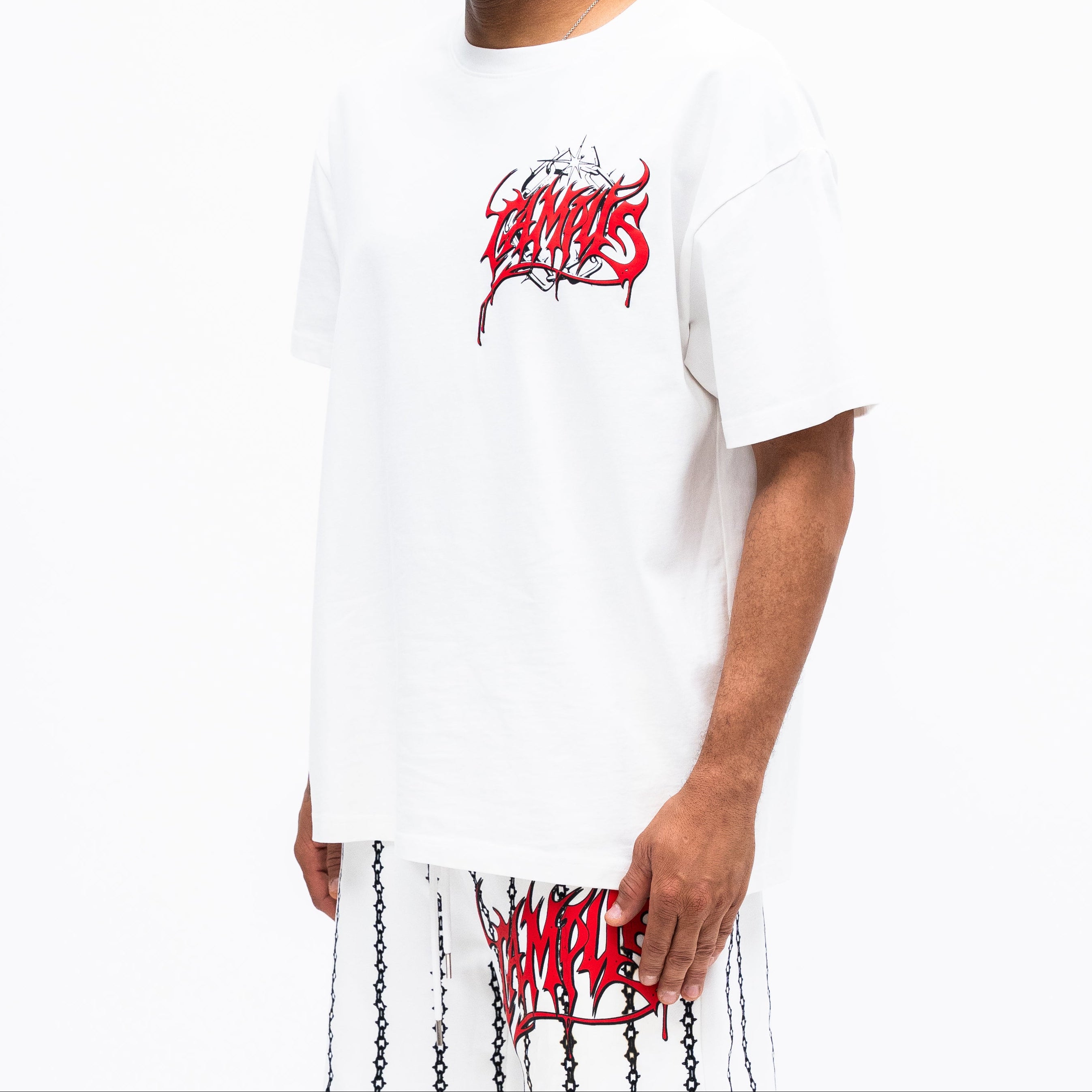 Man wearing a white t-shirt with red and black graphics on a white background